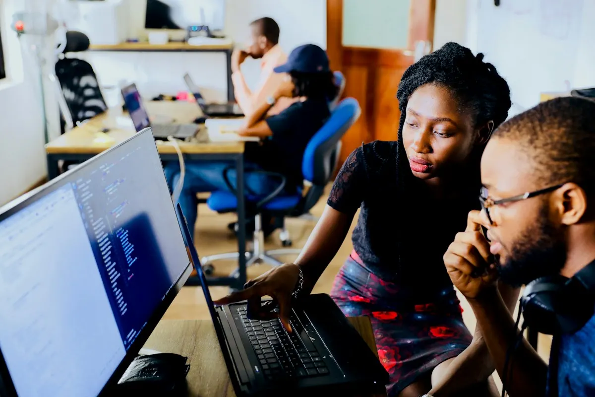 Two developers working together in front of a laptop
